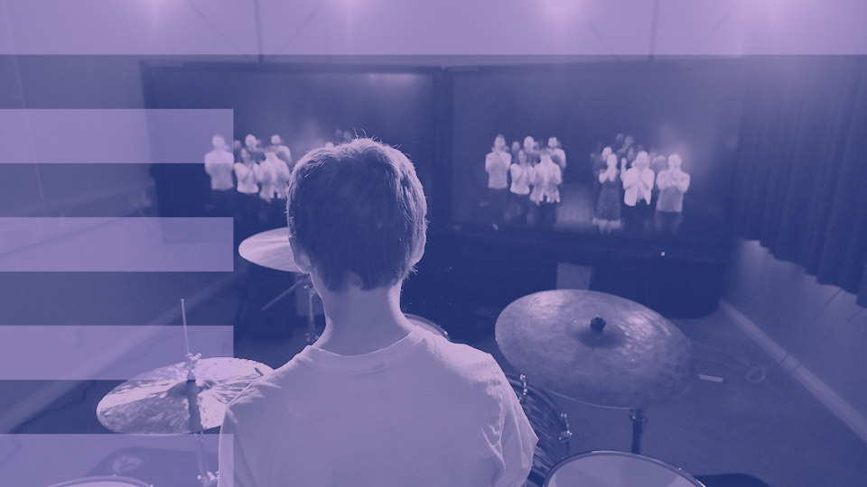 A purple filter on a photo of a drummer in performance simulator